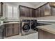 Laundry room with espresso cabinets and stainless steel washer and dryer at 2219 E Galileo Dr, Gilbert, AZ 85298