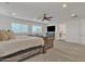 This large main bedroom suite boasts a ceiling fan, a large bed, and views of the ensuite bathroom at 2219 E Galileo Dr, Gilbert, AZ 85298