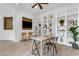Spacious home office has custom built-in shelving, ceiling fan, and a cozy seating area with outdoor views at 2219 E Galileo Dr, Gilbert, AZ 85298