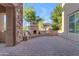 Beautiful outdoor patio with a cozy fireplace, built-in seating, and a serene backyard view at 2219 E Galileo Dr, Gilbert, AZ 85298