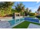 Backyard with pool and water feature, lush vegetation, patio furniture, and lounge chairs at 2219 E Galileo Dr, Gilbert, AZ 85298