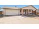 Inviting single-story home with attached garage, covered porch supported by brick pillars, and a paved driveway at 2227 N 57Th Dr, Phoenix, AZ 85035