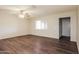 Bright living room with wood-look flooring, a ceiling fan, and a large window bringing in natural light at 2227 N 57Th Dr, Phoenix, AZ 85035
