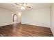 Spacious living room featuring wood-look floors and an arched brick entryway to another room at 2227 N 57Th Dr, Phoenix, AZ 85035