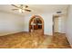 Open living room with tile flooring and brick archway leading to the kitchen with wooden cabinetry at 2227 N 57Th Dr, Phoenix, AZ 85035