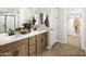 Bright bathroom featuring a double vanity, tile floors, and walk in closet access at 22631 W Irma Ln, Surprise, AZ 85387