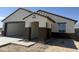 Charming single-story home features a covered entryway and a spacious two-car garage, awaiting personalized landscaping at 22631 W Irma Ln, Surprise, AZ 85387