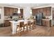 Modern kitchen featuring a stainless-steel refrigerator, wooden cabinetry, and an island with seating at 22631 W Irma Ln, Surprise, AZ 85387
