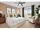 Relaxing primary bedroom suite with large window, curtains, plush chair and coordinating furniture at 22631 W Irma Ln, Surprise, AZ 85387