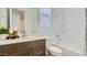 Bright bathroom with modern vanity, shower-tub combo, and tiled walls at 23334 W Mobile Ln, Buckeye, AZ 85326