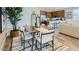 Bright dining area with modern table and stylish decor, seamlessly flowing into the open kitchen at 23334 W Mobile Ln, Buckeye, AZ 85326