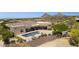 Expansive desert estate featuring a refreshing pool with fountains and lush landscaping surrounded by desert and mountain views at 24200 N Alma School Rd # 7, Scottsdale, AZ 85255