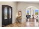 Inviting foyer with travertine flooring, arched doorway, and a view of the piano room at 24200 N Alma School Rd # 7, Scottsdale, AZ 85255