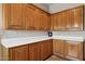 Kitchen featuring custom wood cabinets, white countertops, tile flooring, and natural lighting at 24200 N Alma School Rd # 7, Scottsdale, AZ 85255