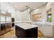 Bright kitchen with a large center island, white cabinetry, stainless steel appliances, and tile flooring at 24200 N Alma School Rd # 7, Scottsdale, AZ 85255
