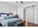 Bright main bedroom featuring stylish decor, wood floors, and a barn door leading to the bathroom at 24200 N Alma School Rd # 7, Scottsdale, AZ 85255