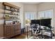 Well-lit home office featuring hardwood floors, built-in shelving, modern desk, and natural lighting at 24200 N Alma School Rd # 7, Scottsdale, AZ 85255