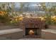 Charming outdoor fireplace creates a cozy ambiance, complemented by the serene backdrop of desert foliage at 24200 N Alma School Rd # 7, Scottsdale, AZ 85255