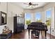 Bright piano room with wood floors, plantation shutters, and a grand piano at 24200 N Alma School Rd # 7, Scottsdale, AZ 85255