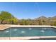 Beautiful pool with a travertine surround and fountain features surrounded by mountain views and desert landscaping at 24200 N Alma School Rd # 7, Scottsdale, AZ 85255