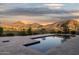 Stunning backyard pool with stone surround, reflecting a serene sky and overlooking picturesque mountain scenery at 24200 N Alma School Rd # 7, Scottsdale, AZ 85255
