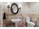 Elegant powder room featuring decorative tile, pedestal sink, black framed round mirror, and sconce lighting at 24200 N Alma School Rd # 7, Scottsdale, AZ 85255