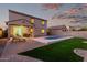 Landscaped backyard with a pool and covered patio against the backdrop of a colorful dusk sky at 2993 E Meadowview Dr, Gilbert, AZ 85298