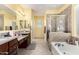 A bright bathroom with double sinks, separate shower, and tiled bathtub at 2993 E Meadowview Dr, Gilbert, AZ 85298