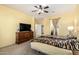 Comfortable main bedroom featuring a ceiling fan and dresser with a TV at 2993 E Meadowview Dr, Gilbert, AZ 85298