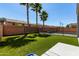 Fully fenced backyard with artificial grass, palm trees, and a sparkling pool at 30165 W Flower St, Buckeye, AZ 85396
