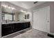 Bathroom with a double vanity, granite countertop, decorative mirrors and a tiled shower at 30165 W Flower St, Buckeye, AZ 85396