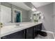 Bathroom featuring a dual sink vanity with dark cabinets, a large mirror and tiled floors at 30165 W Flower St, Buckeye, AZ 85396