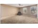 Neutral bedroom featuring a ceiling fan, carpet floors, and natural light from the windows at 30165 W Flower St, Buckeye, AZ 85396