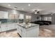 Kitchen with an island featuring granite counters and stainless appliances open to the living room at 30165 W Flower St, Buckeye, AZ 85396
