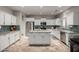 Bright open kitchen with white cabinets, stainless steel appliances, granite counters, and a center island at 30165 W Flower St, Buckeye, AZ 85396