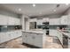 Bright kitchen with white cabinets, granite countertops, stainless steel appliances and center island at 30165 W Flower St, Buckeye, AZ 85396