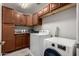 Well-organized laundry room offering modern appliances, storage cabinets, and tile flooring at 30165 W Flower St, Buckeye, AZ 85396
