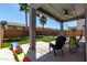 Covered patio with seating overlooking artificial grass and the backyard pool at 30165 W Flower St, Buckeye, AZ 85396