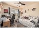 This cozy bedroom offers a relaxing space with a ceiling fan, desk and comfortable furniture at 30259 N Sunray Dr, San Tan Valley, AZ 85143