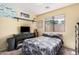 Well-lit bedroom with a camouflage-patterned bedspread, a black dresser, and aviation-themed decor at 30259 N Sunray Dr, San Tan Valley, AZ 85143