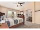 Bright main bedroom featuring a ceiling fan, large window, and ensuite bathroom with double sinks at 30259 N Sunray Dr, San Tan Valley, AZ 85143