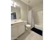 Well-lit bathroom featuring a shower-tub combo with a striped shower curtain and a white vanity at 322 S Soledad Ct, Casa Grande, AZ 85194