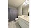 Clean bathroom features a shower with curtain, a vanity with sink, and neutral-toned tile flooring at 322 S Soledad Ct, Casa Grande, AZ 85194
