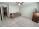Bright bonus room featuring neutral carpet, a ceiling fan, and a comfortable brown sofa at 322 S Soledad Ct, Casa Grande, AZ 85194