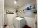 Efficient laundry room with modern washer/dryer, ample shelving, and space-saving ironing board at 322 S Soledad Ct, Casa Grande, AZ 85194