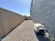 A zero-scaped side yard of the home has a concrete block wall, gravel, and a pet house at 322 S Soledad Ct, Casa Grande, AZ 85194