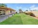 Spacious backyard featuring a covered patio, well-maintained lawn, storage shed, and a block fence at 4062 W Eva St, Phoenix, AZ 85051