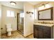 Bright bathroom featuring a glass-enclosed shower, tile flooring, and a modern vanity with ample storage space at 4062 W Eva St, Phoenix, AZ 85051