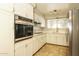 Updated kitchen featuring white cabinets, stainless steel appliances, quartz countertops, and a window with a view at 4062 W Eva St, Phoenix, AZ 85051