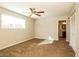 Spacious main bedroom with a ceiling fan, carpet flooring, and a view of the backyard at 4062 W Eva St, Phoenix, AZ 85051
